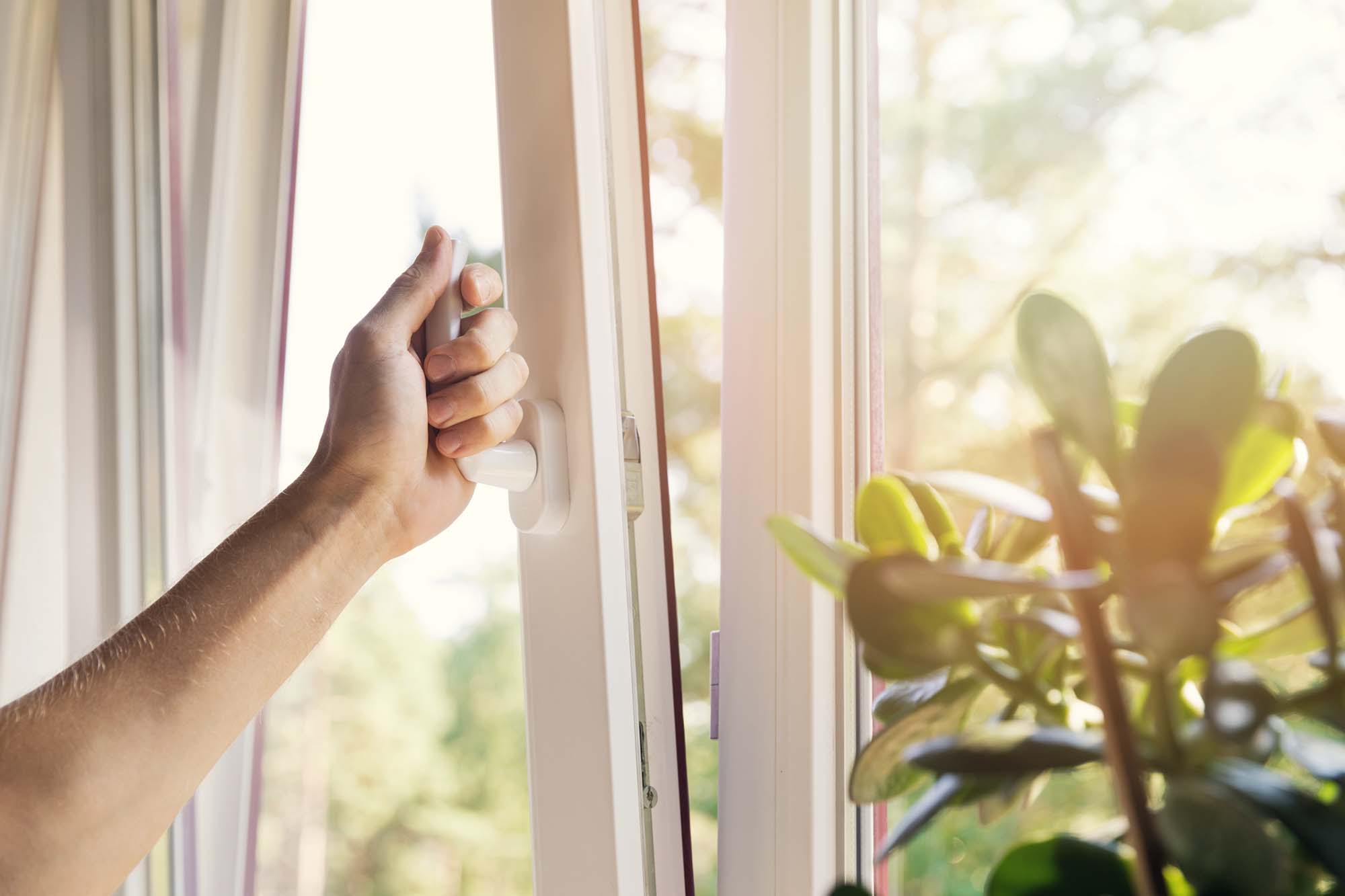 Hand open white plastic pvc window at home